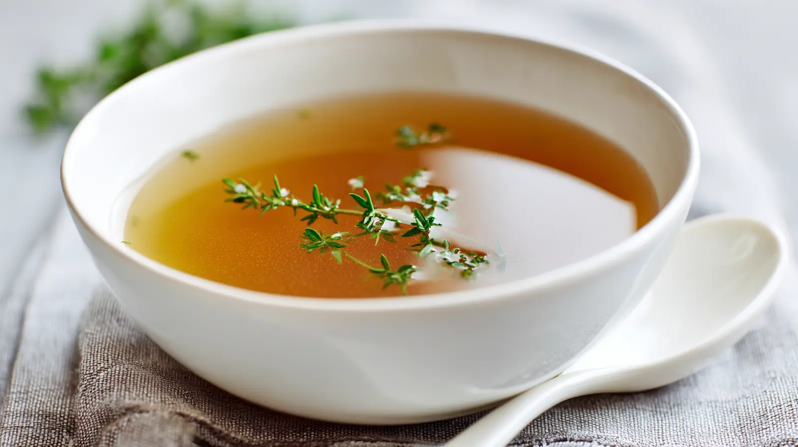 bone broth recipe in stockpot with fresh vegetables and ingredients