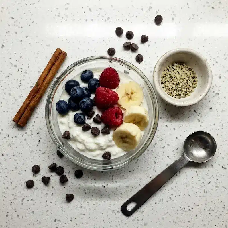 Yogurt Clusters Ingredients Flat Lay ingredients for yogurt clusters recipe including Greek yogurt blueberries raspberries and hemp seeds